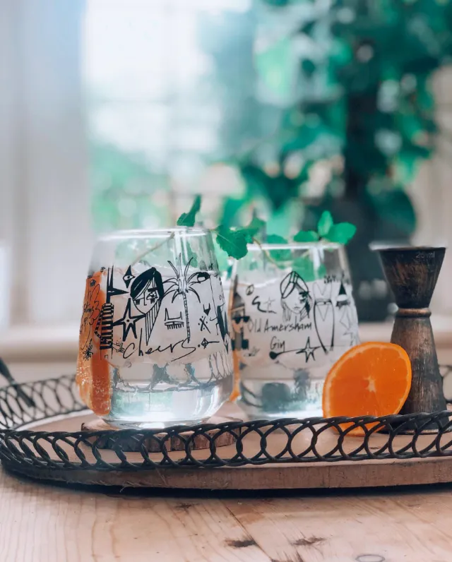 Two artistically designed glasses with water and a citrus slice on a tray by Nadia Flower
