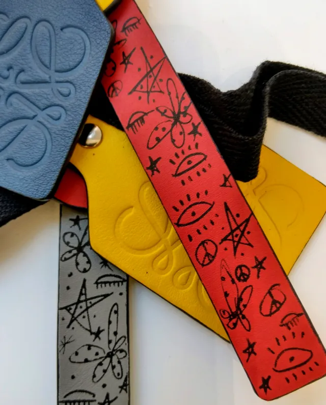 Colorful leather accessories with embossed logos and black doodle drawings by Nadia Flower