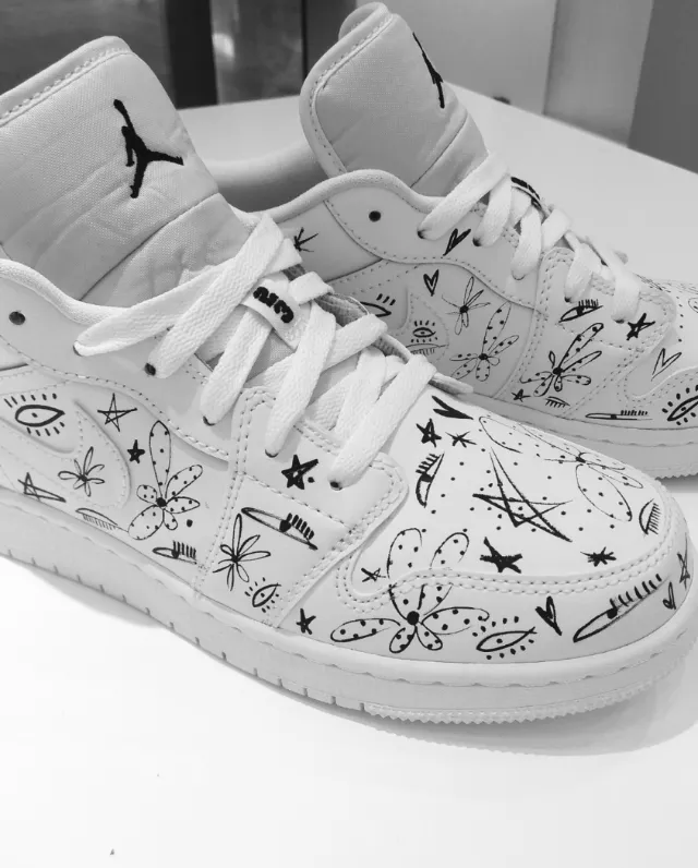 White Air Jordan sneakers with black artistic doodles by Nadia Flower