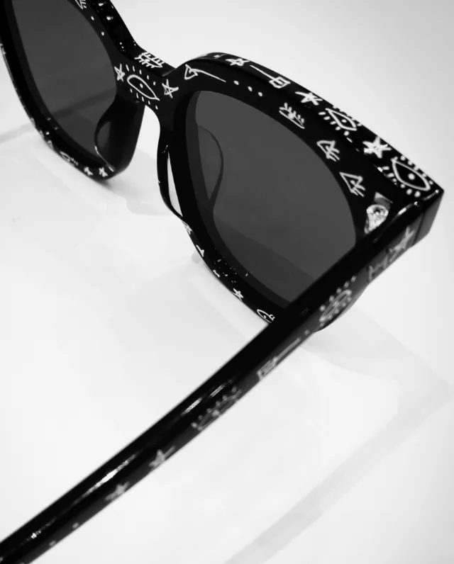 Black sunglasses with white symbols on frame and arms by Nadia Flower