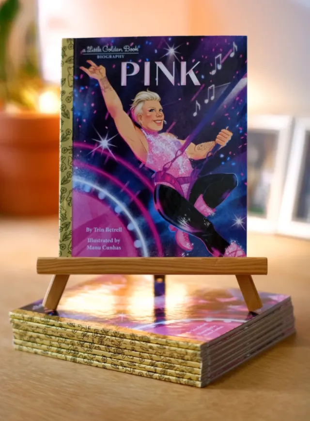 Manu Cunhas illustration of a Pink biography book on a wooden easel