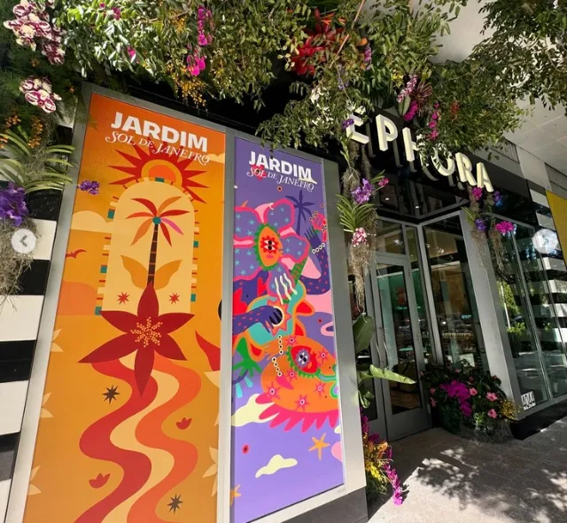 Barbara Tamilin artwork on colorful floral banners outside a garden storefront