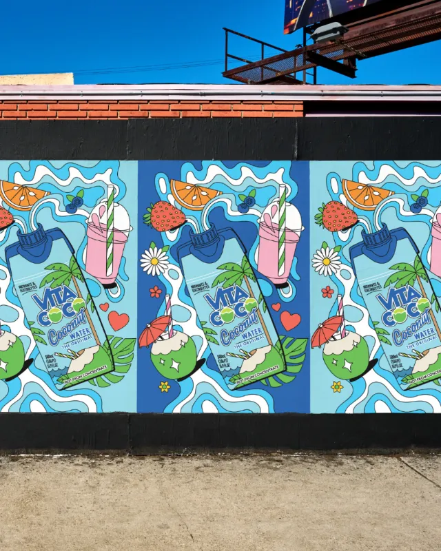 Colorful repeated mural by Season of Victory featuring fruit, flowers, waves, and beverage cartons.