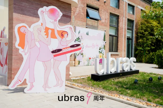 Albert Morell's pastel Ubras anniversary installation with fashion figures and a large outdoor logo.