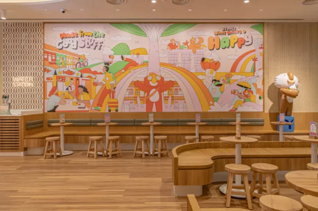 Colorful café mural with rainbows and playful figures by Joseph Carrington