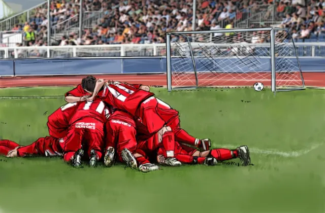 Rugby match, players with red dress sitting on the ground, green grass on the field