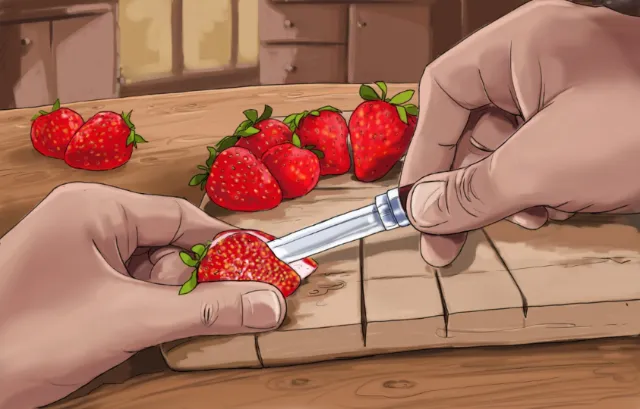 hands with a knife cutting straw berry, fruits on the kitchen table