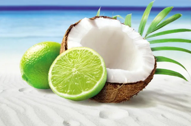 Coconut and lime on white sand beach by Tom Ungemach