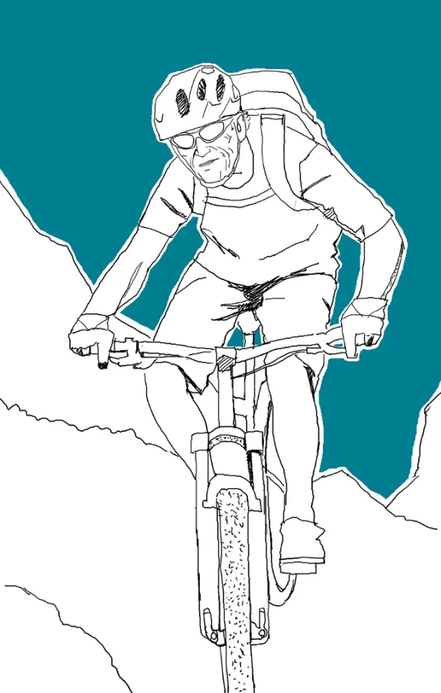 Mountain biker wearing helmet and backpack riding on rough terrain by Andreas Schickert