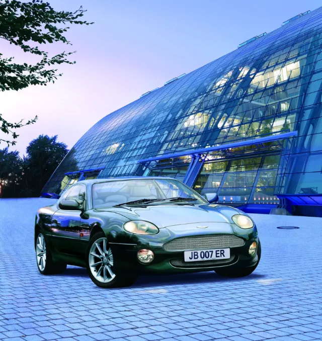 Jaguar XK8 sports car parked by glass building by Eberhard Reimann